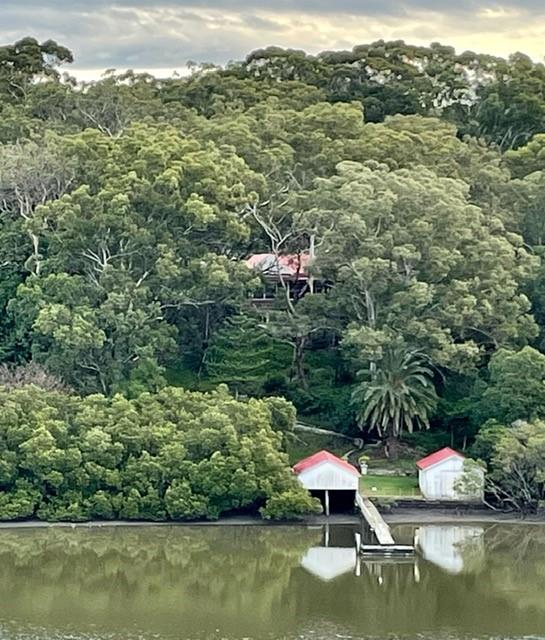 Glenlee cottage among trees above the river